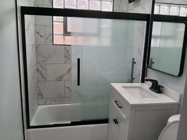 bathroom with toilet, shower / bath combination with glass door, and vanity