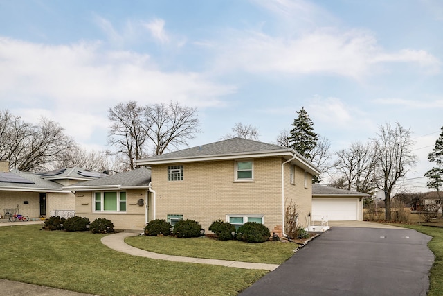 view of side of property featuring a garage, brick siding, and a yard