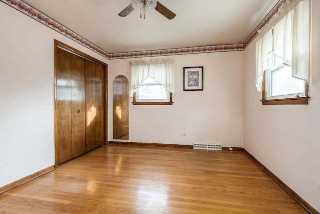 unfurnished bedroom with light wood-type flooring, visible vents, baseboards, and multiple windows