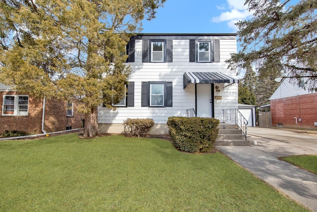 view of front of house featuring a garage, driveway, a front lawn, and an outdoor structure