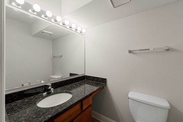 bathroom with baseboards, vanity, and toilet