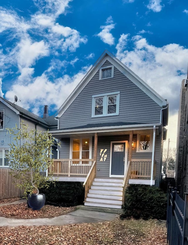 view of front of property with a porch and fence