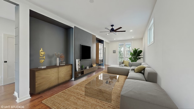 living room featuring baseboards, wood finished floors, a ceiling fan, and recessed lighting