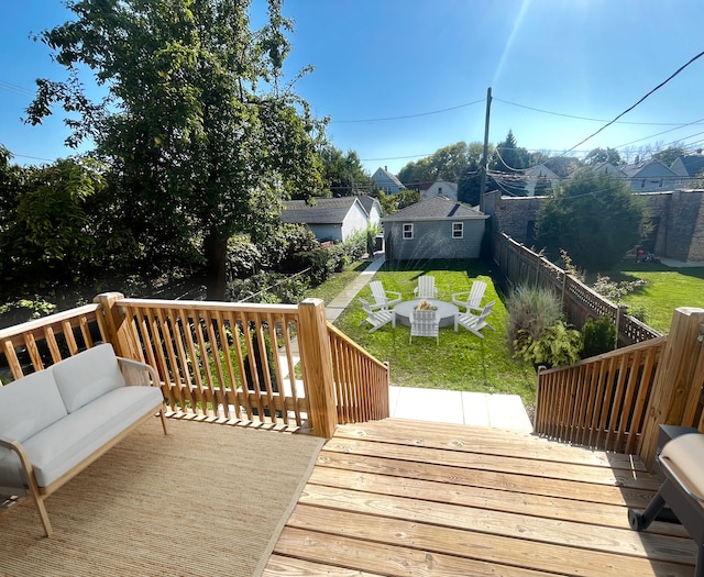 wooden deck with a yard, a fenced backyard, and an outdoor living space with a fire pit