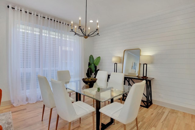 dining room featuring baseboards, wood finished floors, and an inviting chandelier