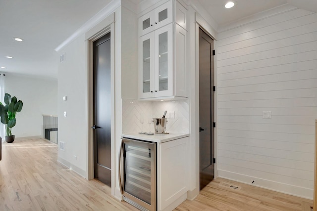 bar featuring a dry bar, visible vents, decorative backsplash, wine cooler, and light wood-style floors