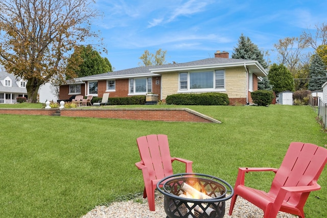 ranch-style house with brick siding, a chimney, a storage unit, and a front yard