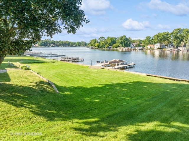 dock area featuring a lawn and a water view