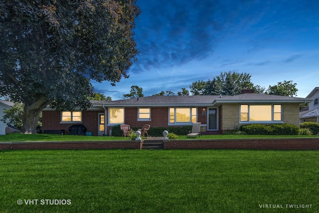 single story home with brick siding, a chimney, and a front yard