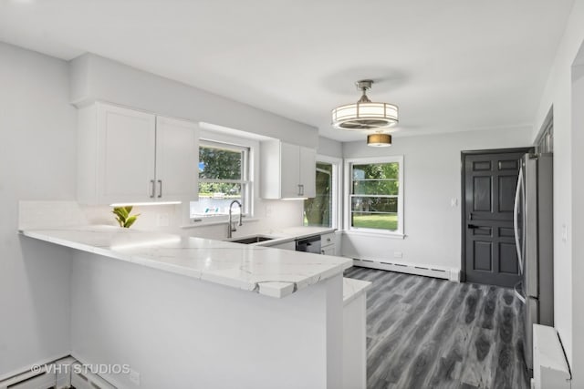 kitchen with white cabinets, a baseboard radiator, appliances with stainless steel finishes, light stone countertops, and a sink