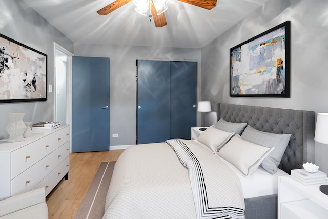 bedroom featuring a ceiling fan, a closet, light wood-style flooring, and baseboards