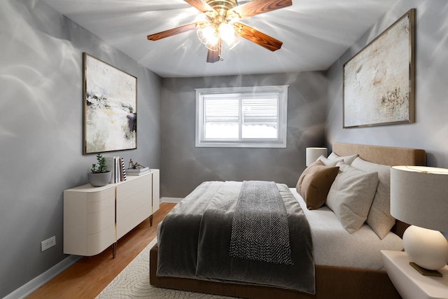 bedroom with ceiling fan, baseboards, and wood finished floors