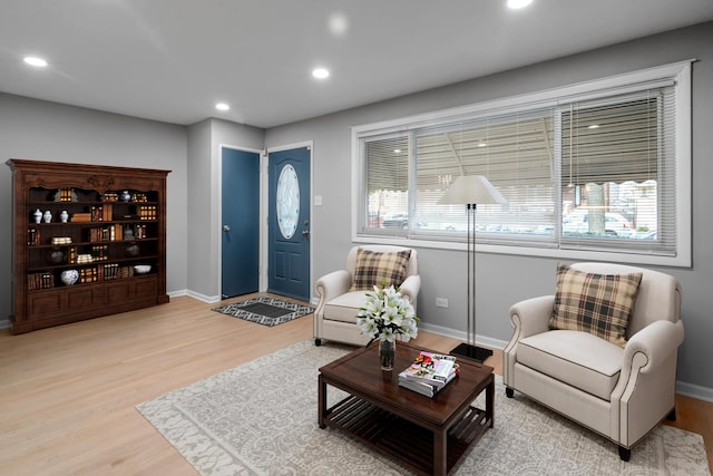 living room with baseboards, light wood finished floors, and recessed lighting