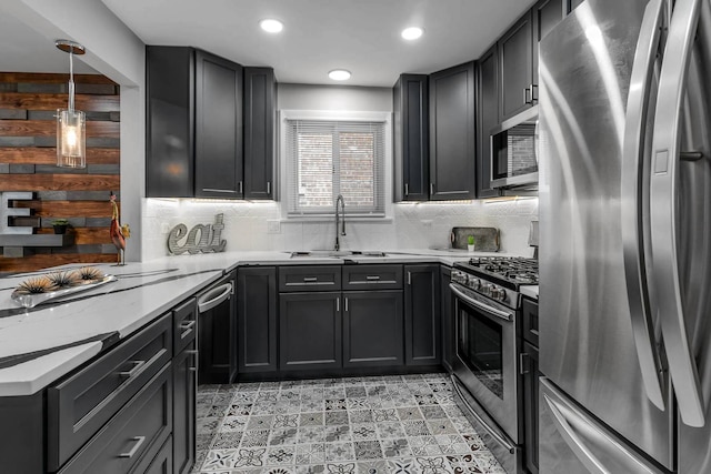 kitchen with pendant lighting, recessed lighting, backsplash, appliances with stainless steel finishes, and a sink