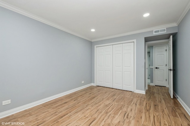 unfurnished bedroom featuring baseboards, ornamental molding, visible vents, and light wood-style floors