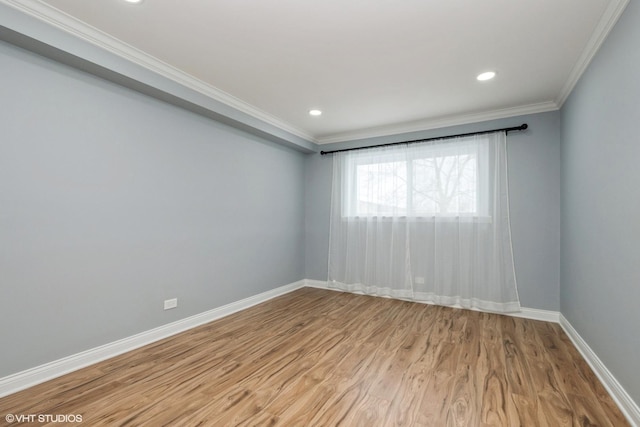 spare room featuring light wood-style floors, baseboards, ornamental molding, and recessed lighting