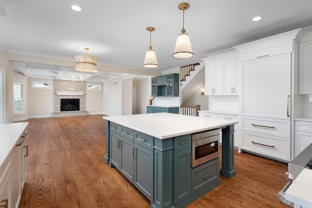 31 Golden Larch Ct, Naperville, IL 60540 - kitchen featuring stainless steel microwave, white cabinetry, light countertops, and wood finished floors
