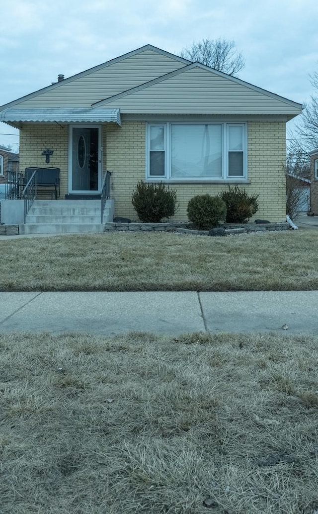 view of front of house with a front lawn and brick siding