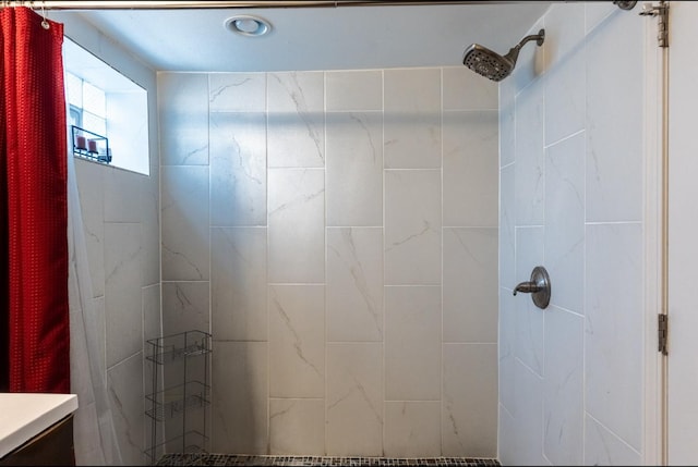 bathroom featuring tiled shower and vanity