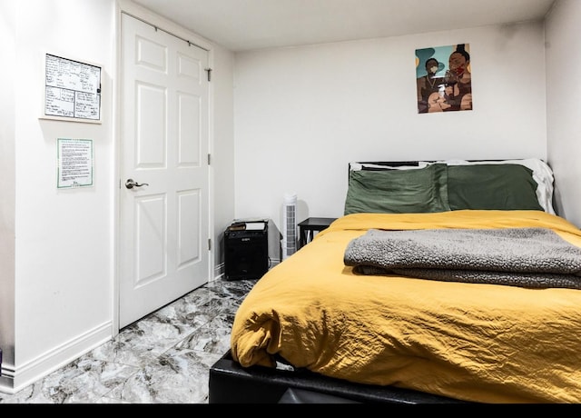 bedroom featuring marble finish floor and baseboards