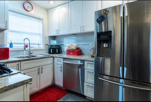 kitchen featuring stainless steel appliances, tasteful backsplash, and white cabinetry