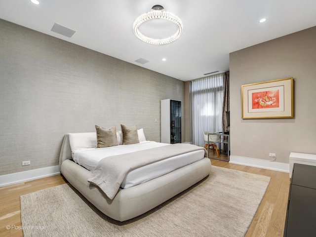 bedroom with recessed lighting, light wood-style flooring, baseboards, and wallpapered walls