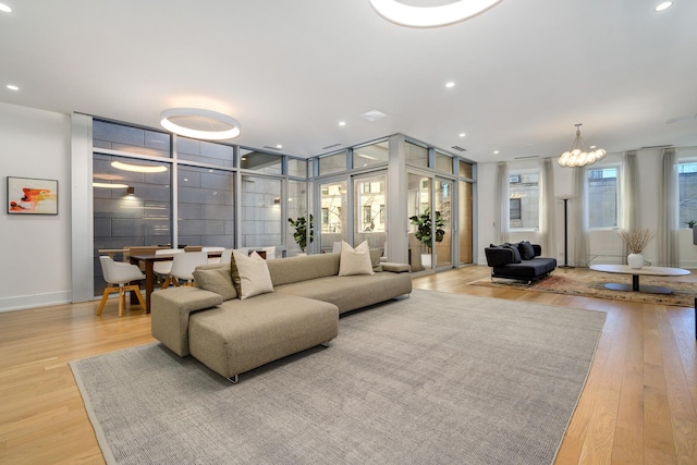 living room with a chandelier, recessed lighting, and light wood-style flooring