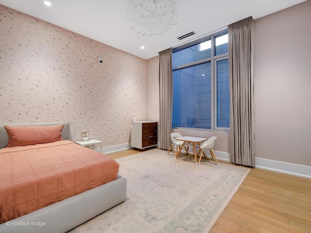 bedroom with recessed lighting, wood finished floors, visible vents, baseboards, and wallpapered walls