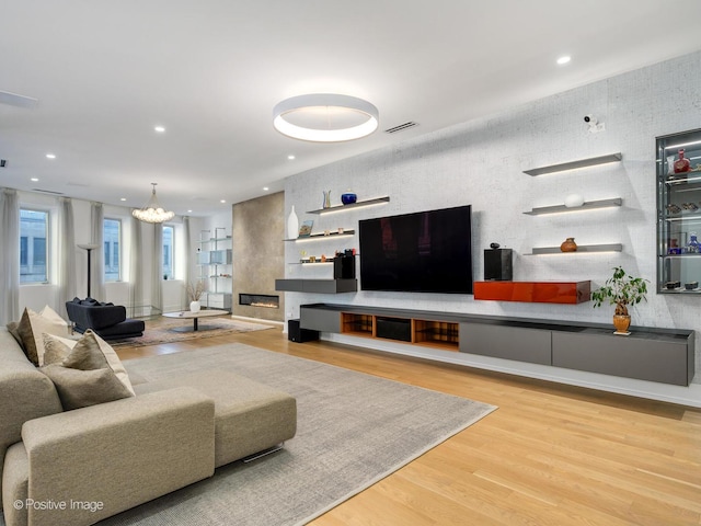 living area featuring recessed lighting, visible vents, a fireplace, and wood finished floors