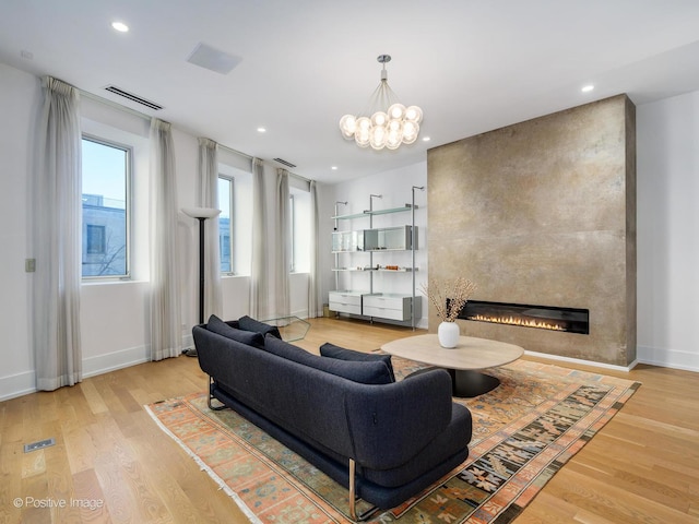 living room with recessed lighting, a large fireplace, wood finished floors, visible vents, and baseboards