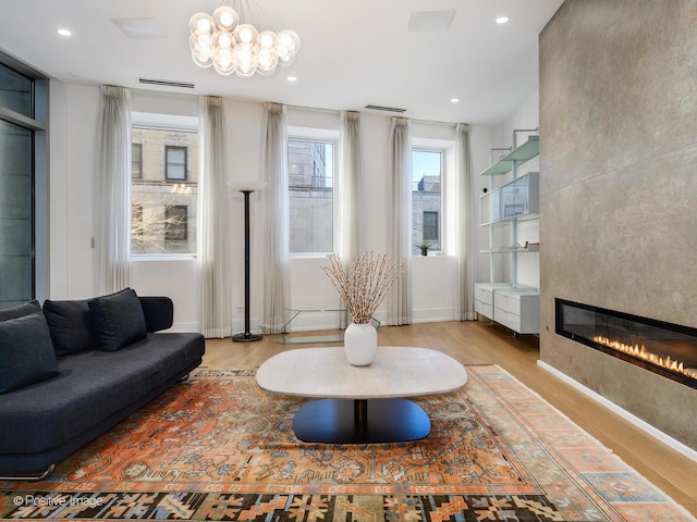 living area with recessed lighting, a large fireplace, baseboards, and wood finished floors