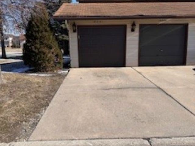 garage featuring concrete driveway