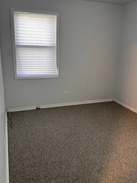 carpeted empty room with baseboards