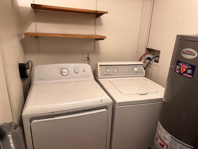 washroom with laundry area, water heater, and independent washer and dryer