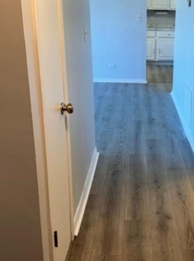 hall with dark wood finished floors and baseboards