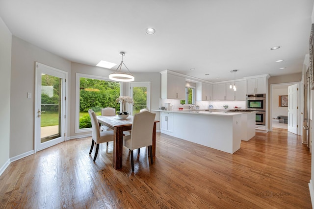 dining area featuring recessed lighting, light wood-style flooring, and baseboards