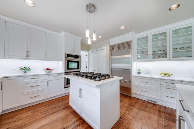 kitchen with stainless steel appliances, visible vents, white cabinets, light countertops, and light wood-type flooring