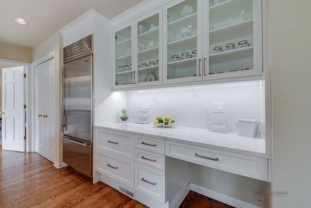 bar with built in fridge, visible vents, and wood finished floors