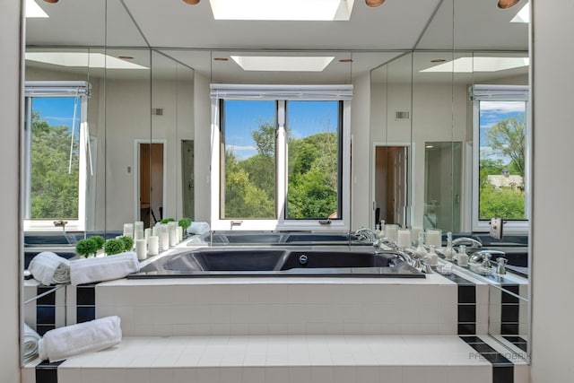 full bathroom with a skylight, a garden tub, and visible vents