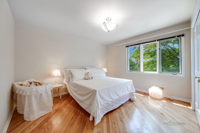 bedroom with light wood-type flooring and baseboards