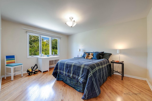 bedroom featuring wood finished floors and baseboards