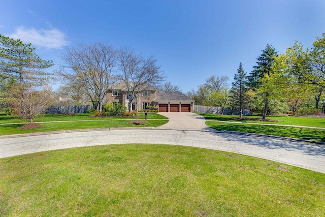 view of front facade with driveway, a garage, fence, and a front yard