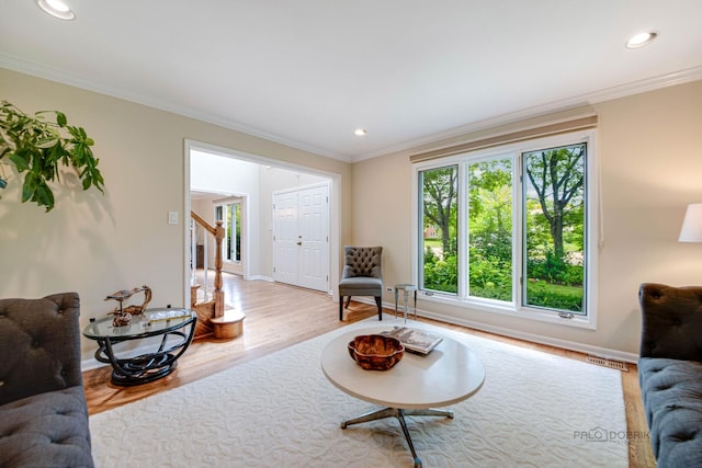 living area with crown molding, recessed lighting, wood finished floors, baseboards, and stairs