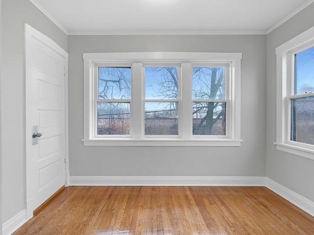 unfurnished room featuring light wood-type flooring, plenty of natural light, and baseboards