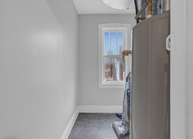 laundry area featuring stacked washer and dryer, wood finished floors, and baseboards