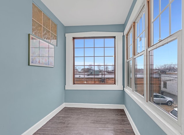 empty room featuring wood finished floors and baseboards