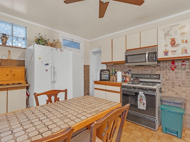 kitchen with freestanding refrigerator, range with gas cooktop, stainless steel microwave, and white cabinets