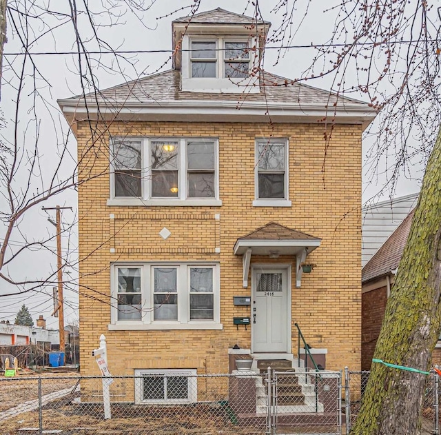 view of front of house featuring a fenced front yard, a gate, and brick siding