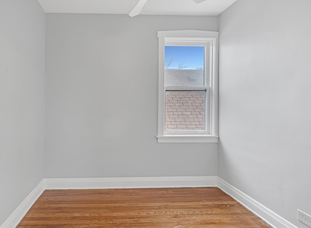 unfurnished room with a ceiling fan, light wood-style flooring, and baseboards