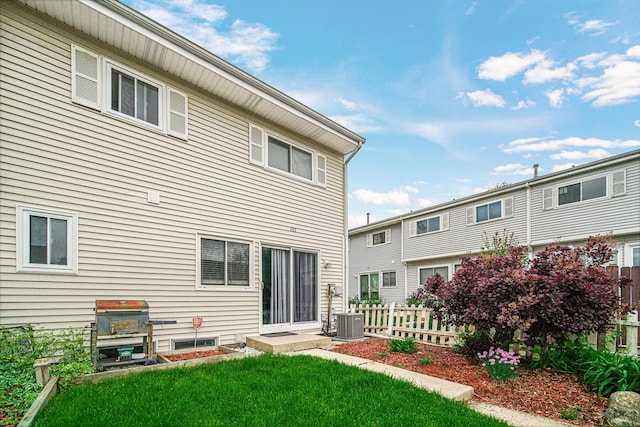 back of house with a yard, central AC unit, and fence